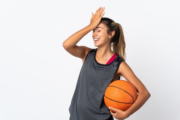 Uma jovem hispânica jogando basquete sobre um fundo branco isolado percebeu algo e tem a intenção de encontrar a solução