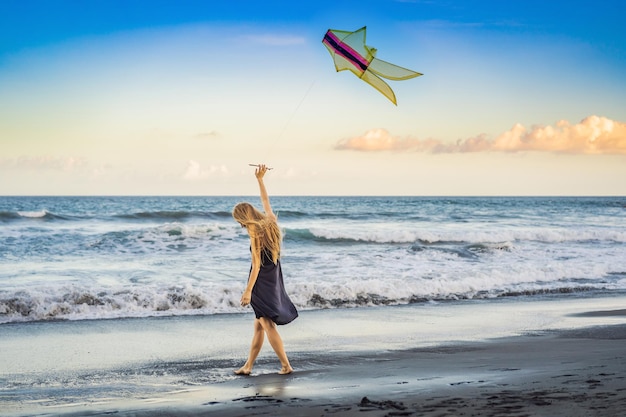 Uma jovem lança uma pipa na praia Sonho aspirações planos futuros