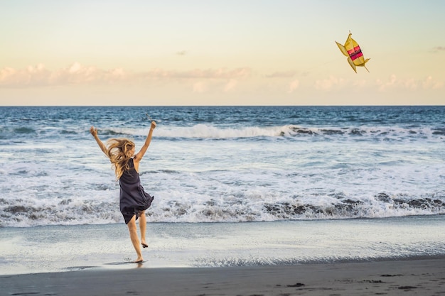 Uma jovem lança uma pipa na praia Sonho aspirações planos futuros