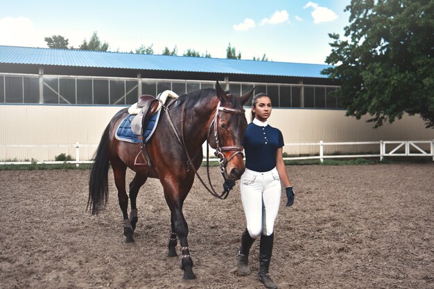 Uma jovem leva seu cavalo para o treinamento e preparação para as corridas do hipódromo