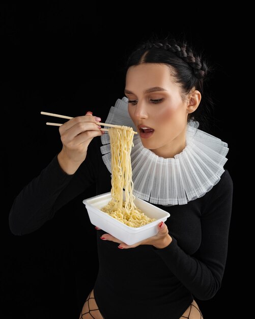 Foto uma jovem linda com macarrão e espaguete a comer sexy.