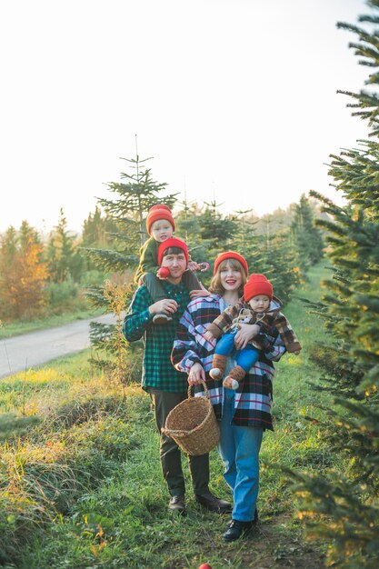 Foto uma jovem linda família escolhe uma árvore de natal no mercado férias de inverno festivas para pais e crianças ecologicamente corretas