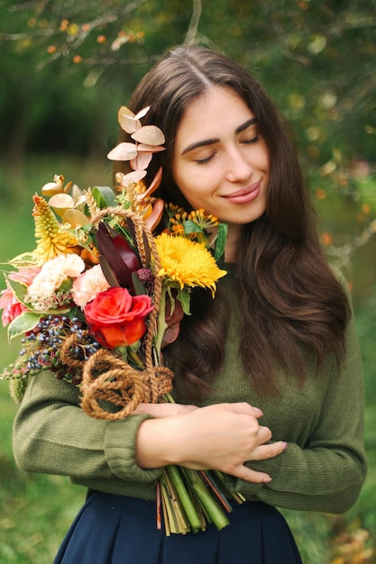 Uma jovem linda morena com flores nas mãos