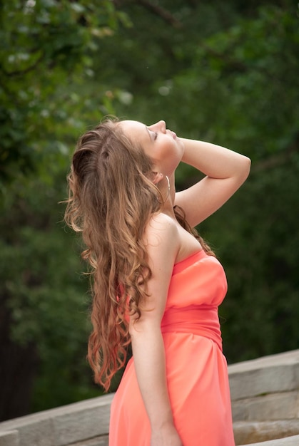 Foto uma jovem linda posa em um vestido vermelho no parque