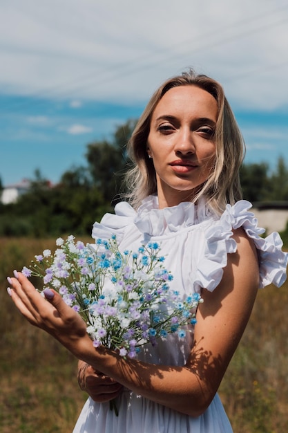 Uma jovem linda tem flores nas mãos