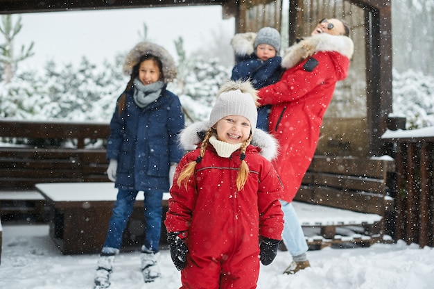 Uma jovem mãe com seus filhos se divertindo no inverno