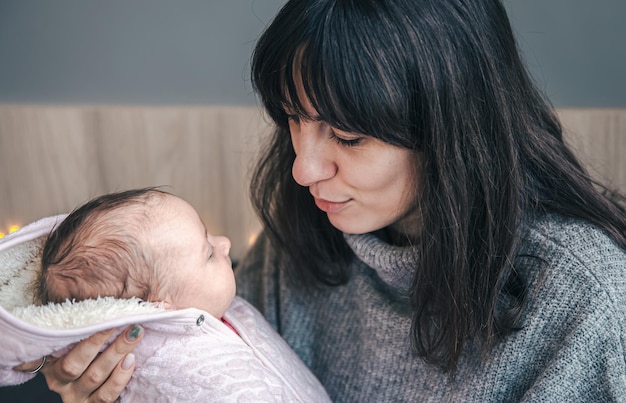 Uma jovem mãe com uma menina recém-nascida nos braços