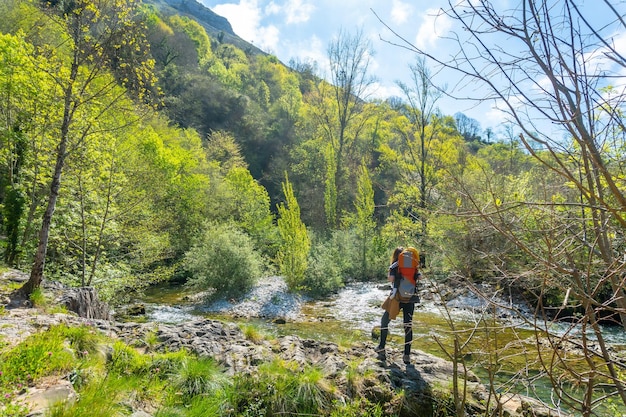 Uma jovem mãe com uma mochila olhando para o rio Sella entre o Tornin e o Olla de San Vicente perto de Cangas de Onis Asturias Espanha