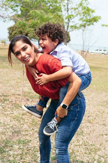 Foto uma jovem mãe e seu filho brincando no parque