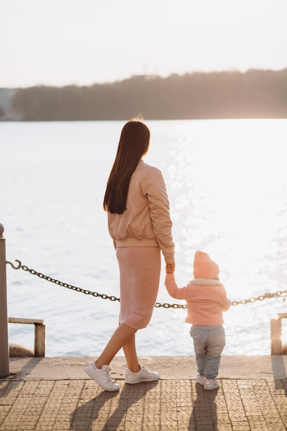 Uma jovem mãe elegante e sua filha passar algum tempo juntos no lago no parque