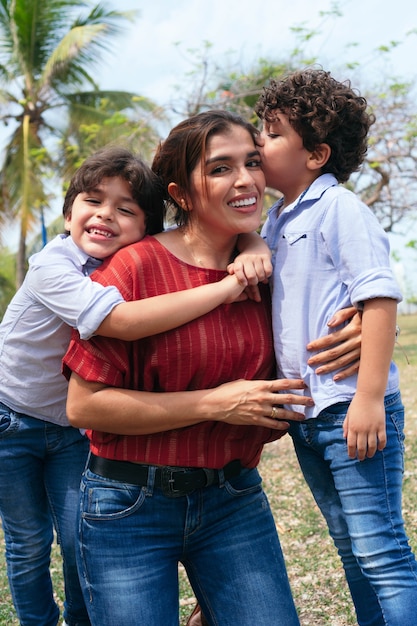 Foto uma jovem mãe hispânica e seus filhos