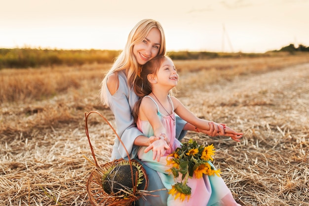 Uma jovem mãe positiva caminha com sua linda filhinha e descansa