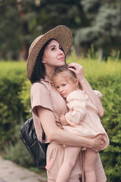 Uma jovem mãe segura a filha nos braços e diz-lhe algo. Dia das Mães