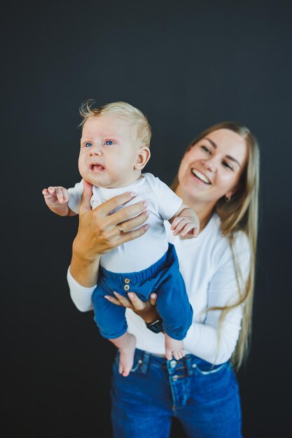 Uma jovem mãe sorridente segura seu filho recém-nascido em seus braços mãe feliz filho e mãe conceito de maternidade feliz