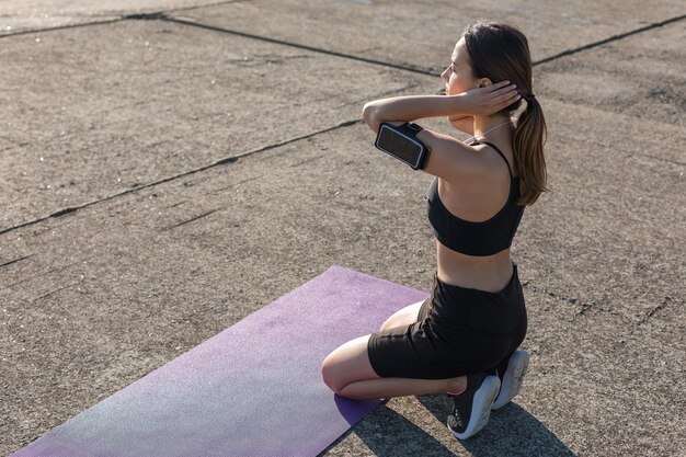 Uma jovem magra e atlética em roupas esportivas realiza uma série de exercícios Fitness e estilo de vida saudável