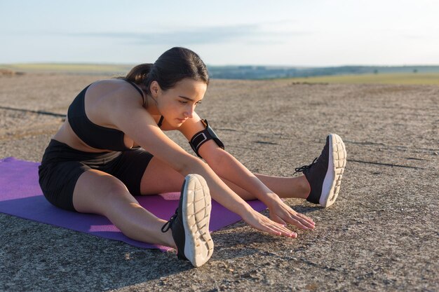 Uma jovem magra e atlética em roupas esportivas realiza uma série de exercícios Fitness e estilo de vida saudável