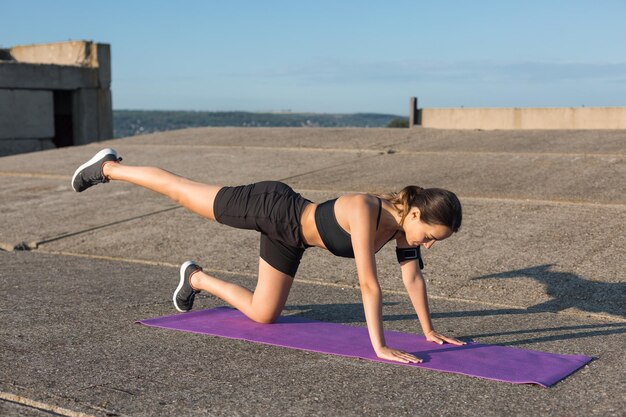 Uma jovem magra e atlética em roupas esportivas realiza uma série de exercícios Fitness e estilo de vida saudável