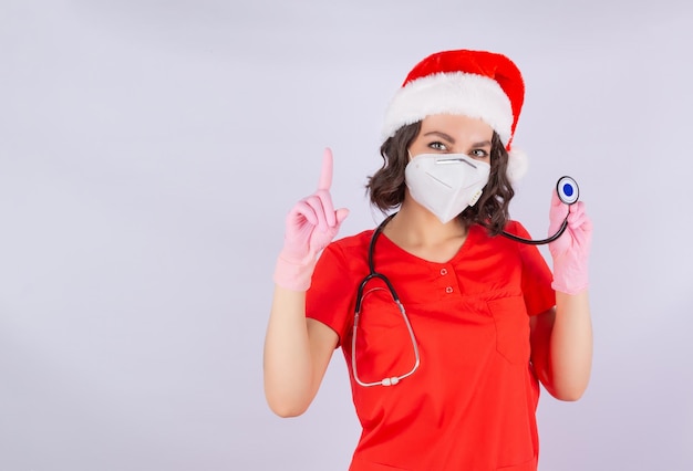 Foto uma jovem médica usando um chapéu de papai noel chama atenção