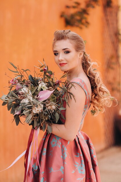 Uma jovem modelo em um lindo vestido com um buquê de flores no campo na França