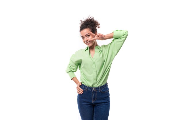 Foto uma jovem modelo feminina esbelta está vestida com uma camisa verde claro em um fundo branco conceito de roupas confortáveis