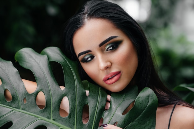 Uma jovem morena linda posando entre densos arvoredos de selva e floresta tropical. Spa