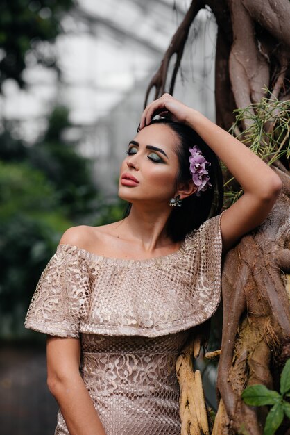 Uma jovem morena linda posando entre densos arvoredos de selva e floresta tropical. spa