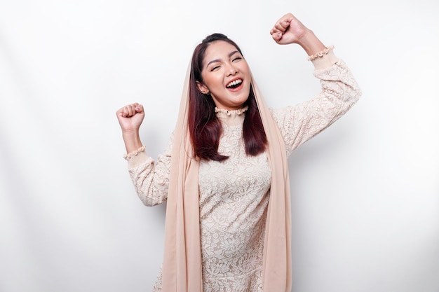 Uma jovem muçulmana asiática com uma expressão feliz e bem-sucedida usando um hijab isolado por fundo branco