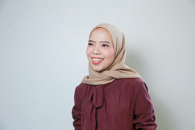 Uma jovem muçulmana asiática sorridente se sente confiante e alegre isolada sobre fundo branco