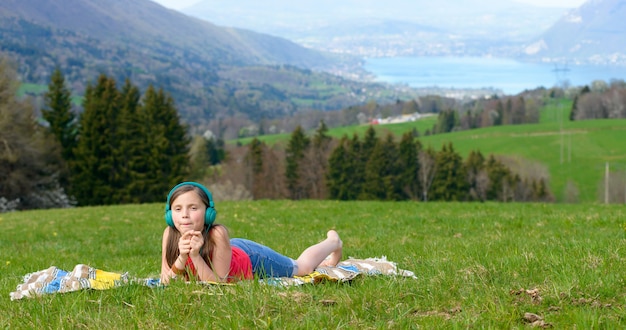 Uma jovem muito bonita ouvindo música na natureza