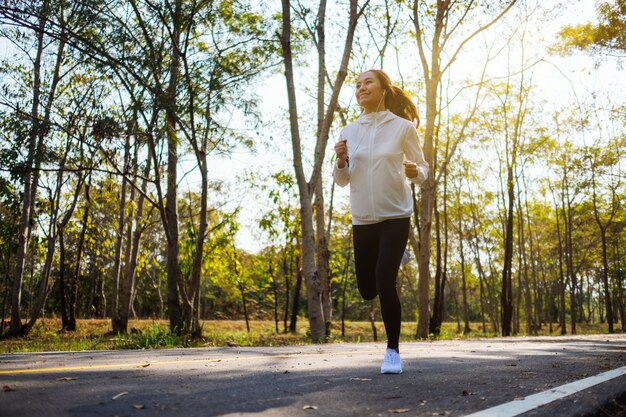 Uma jovem mulher asiática correndo no parque da cidade pela manhã