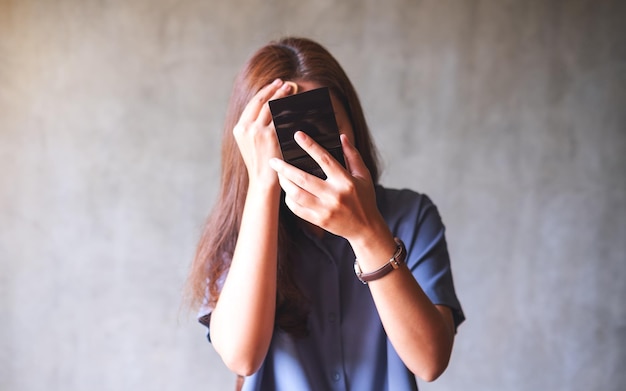 Uma jovem mulher asiática olhando no espelho enquanto coloca maquiagem