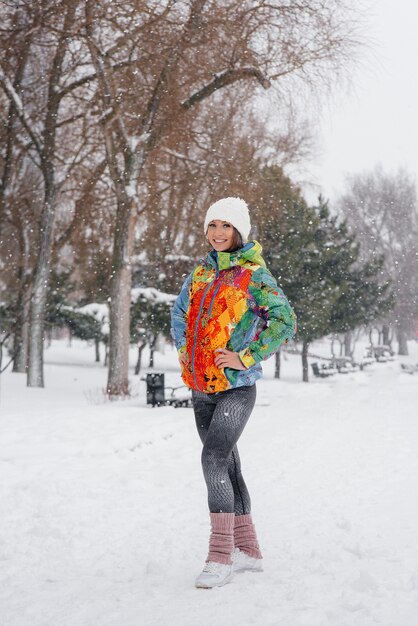 Uma jovem mulher atlética posa em um dia gelado e com neve. Fitness, corrida