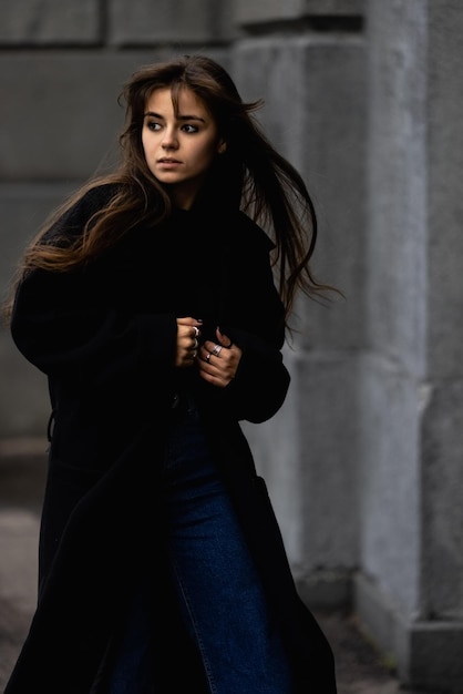 Uma jovem mulher bonita em um casaco preto