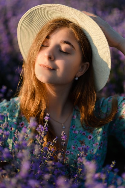 Foto uma jovem mulher com um chapéu em um campo de lavanda