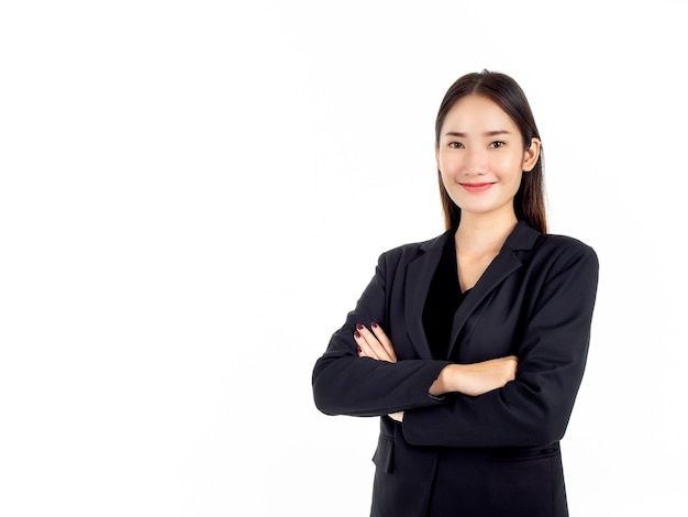 Uma jovem mulher de negócios asiática confiante em um terno preto sorrindo, de pé com os braços cruzados e olhando para a câmera isolada no branco