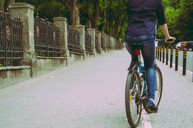 Uma jovem mulher é andar de bicicleta no pôr do sol no parque vintage