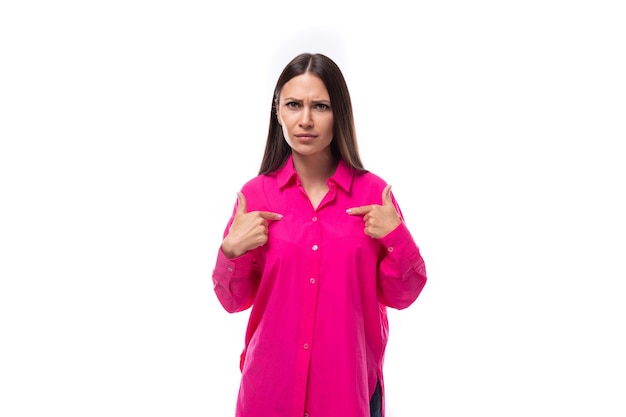 Foto uma jovem mulher europeia morena bonita com uma camisa carmesim usa gestos para manter uma conversa