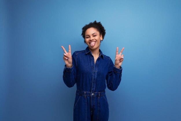 Uma jovem mulher latina morena com um cabelo afro amarrado em um pão está vestida com um jeans azul elegante