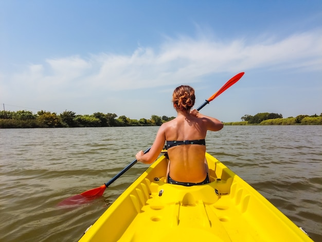 Uma jovem na canoa canoagem em um parque natural na catalunha, um rio próximo à praia em estartit