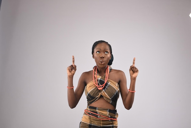 Foto uma jovem negra africana bonita segurando um laptop sorrindo felizmente levantando os dedos