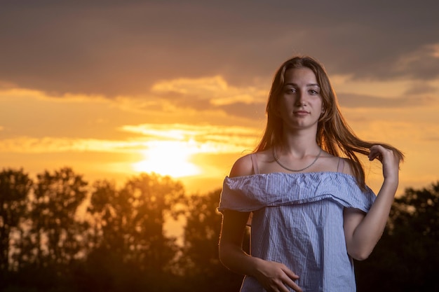 Uma jovem no fundo do pôr do sol