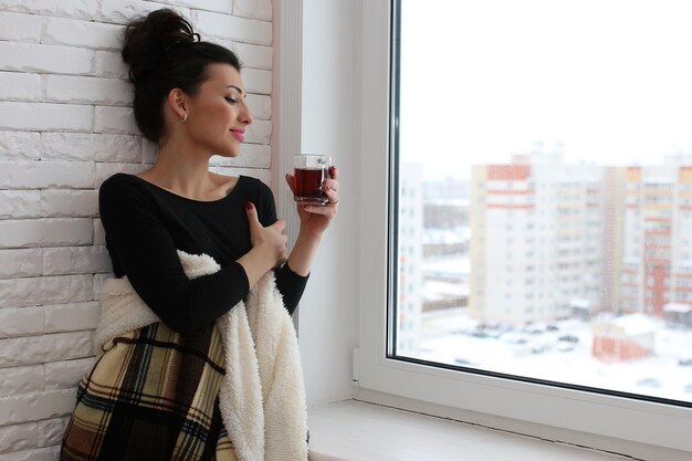 Uma jovem olha pela janela de um novo apartamento