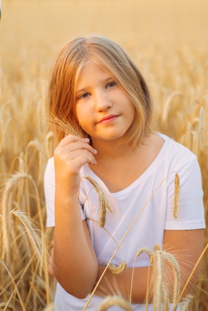 uma jovem ou menina em um campo com trigo caminha ao pôr do sol