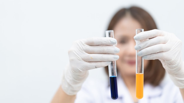 Uma jovem pesquisadora, médica, cientista ou assistente de laboratório trabalhando com tubos médicos de plástico para pesquisar e examinar experimentos científicos em um laboratório moderno. Foto de estoque de educação