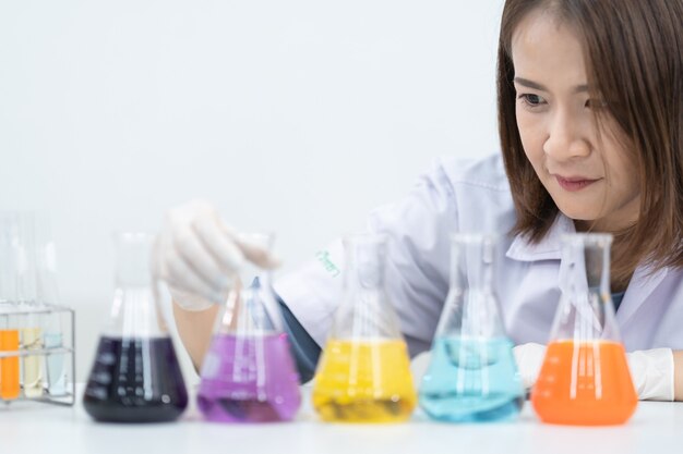 Uma jovem pesquisadora, médica, cientista ou assistente de laboratório trabalhando com tubos médicos de plástico para pesquisar e examinar experimentos científicos em um laboratório moderno. Foto de estoque de educação