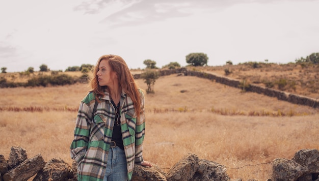 Foto uma jovem posa com um campo ao fundo