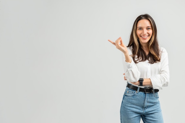 Foto uma jovem radiante com cabelo castanho e uma blusa branca faz gestos com uma mão