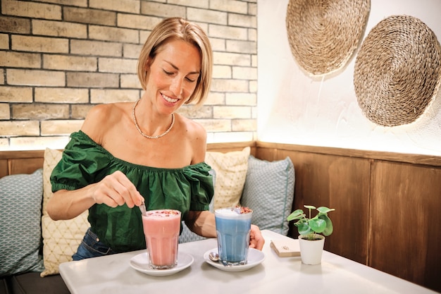 Uma jovem saudável bebendo smoothies coloridos