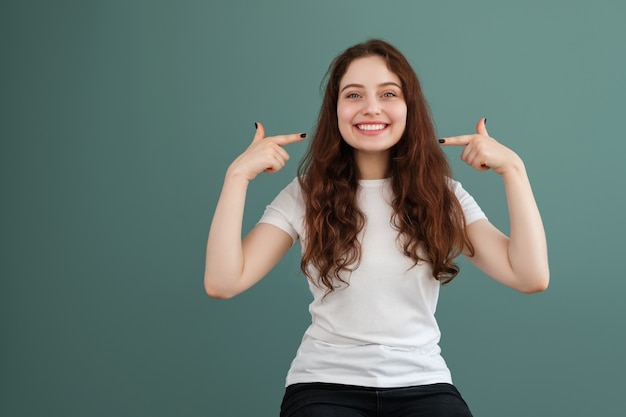 Uma jovem sorri e mostra seus dentes brancos e brilhantes. Sorriso perfeito.