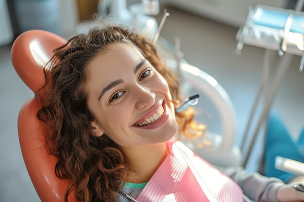 Foto uma jovem sorridente com a boca aberta numa cadeira dentária